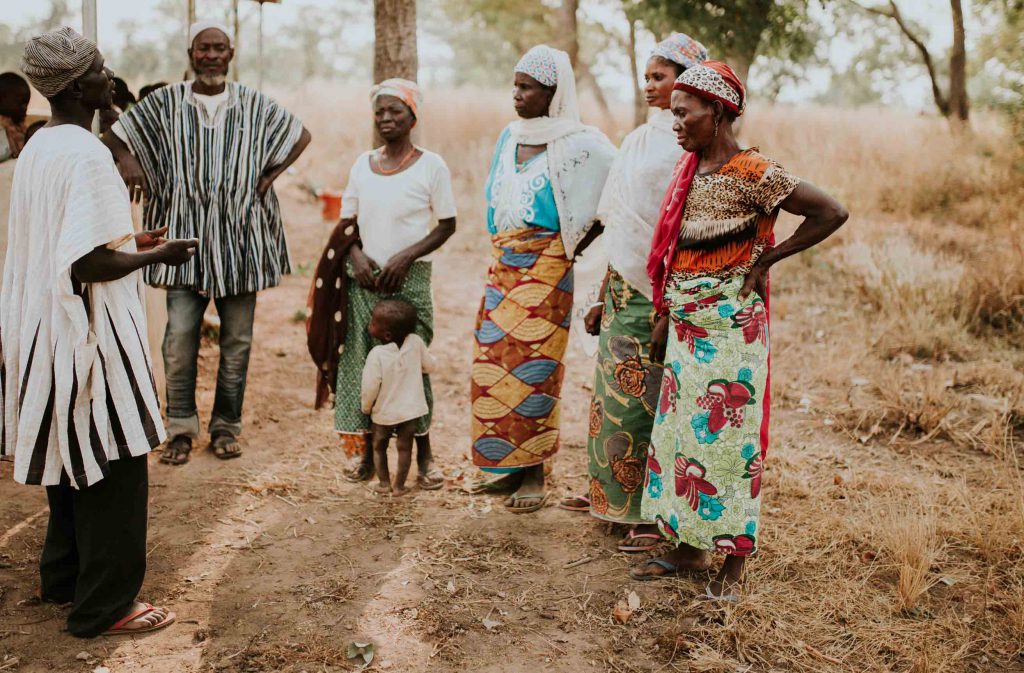 African people listening to local Christian missionary