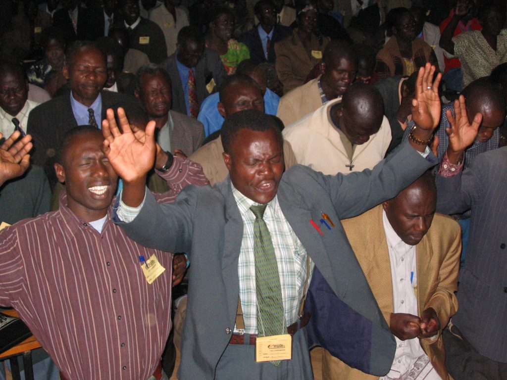 Nigerian Christians sitting and standing in rows worshiping God