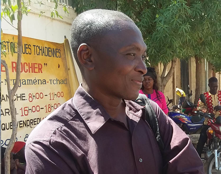 A Chadian man smiling while standing outside by the street