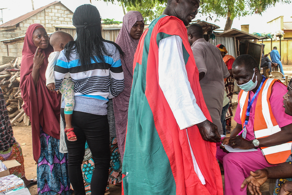 Nigerian men and women stand waiting for medical services