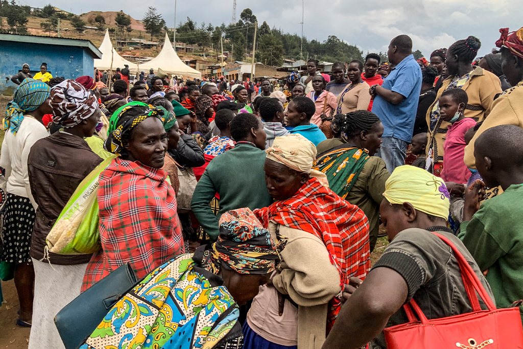 Kenyans gather around a local Christian missionary to hear him preach the gospel