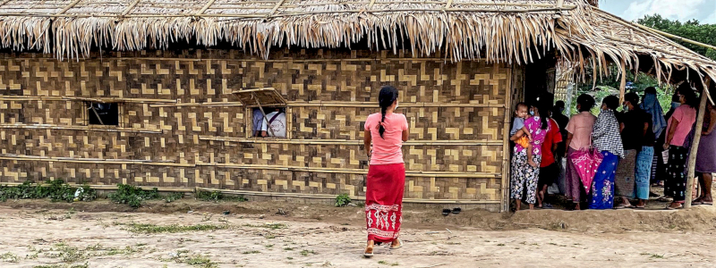 Laos Christians with masks on crowd the door to enter their church