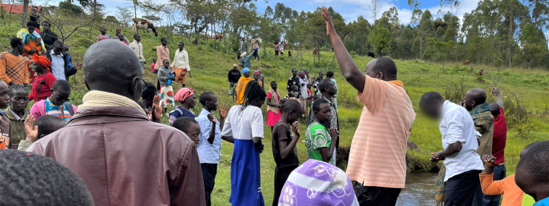 People from Kenyan town gather near riverbanks to pray with local Christian missionary