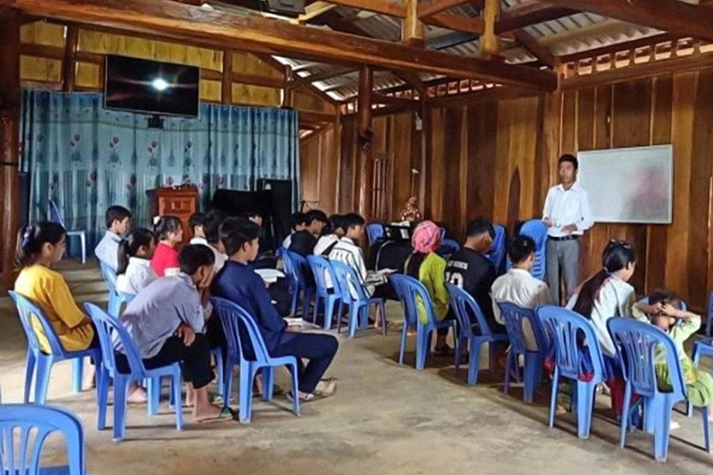 Vietnamese Christian missionary teaches children and teens in church