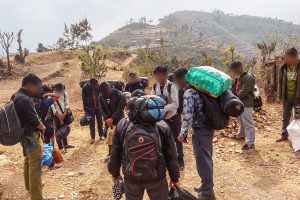 A group of Nepalese Christian men taking a break and praying while hiking through the mountains