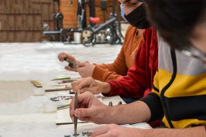 Jordanian men and women work at a table making mosaics
