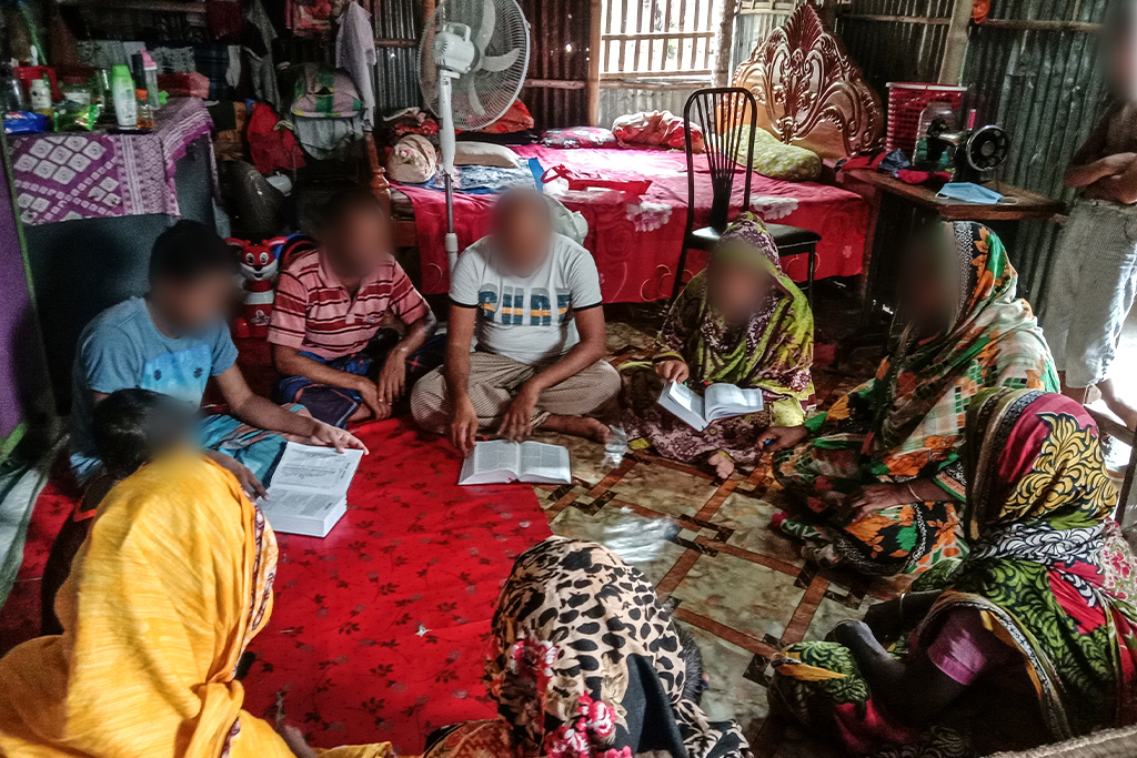 Bangladeshi Christians sit in a circle on the floor studying the Bible together
