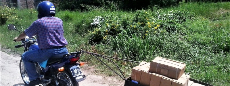Argentinian Evangelist riding a motorcycle pulling a cart of packages