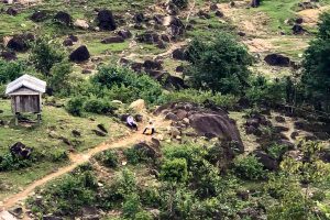 Two men sit on a path on a hillside in Vietnam