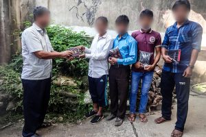 Bangladeshi Christians receive bibles from Christian missionary on the sidewalk
