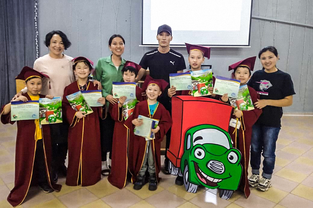 Eurasian Christian children wearing graduation regalia and holding books after graduating from elementary school