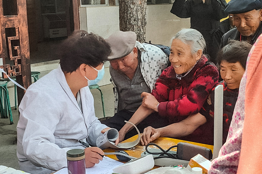 Elderly Chinese men and women preparing to have their blood pressure taken at a health clinic