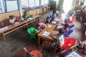 Sri Lankan school children sitting at their desks writing in their notebooks