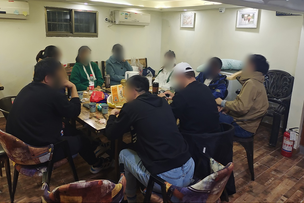 Chinese Christian Men and Women sit around a table in an apartment to study the Bible
