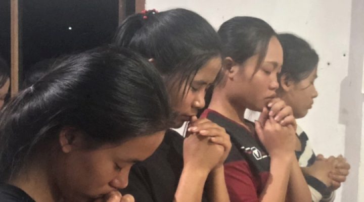 Christian Vietnamese teenage girls pray together